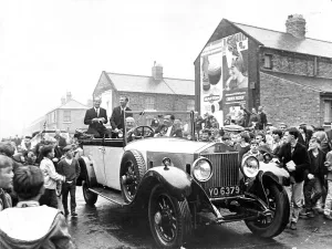 Jack and Bobby Charlton look over-awed as youngsters crowd around the car taking them to Jack and Bobby Charlton look over-awed as youngsters crowd around the car taking them to