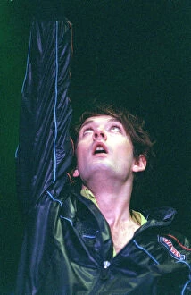 Images Dated 14th July 1996: Jarvis Cocker of pop group Pulp on stage at T in the Park on Sunday with arm raised in