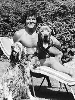 Jess Conrad singer and actor in his garden with two of his unwanted dogs that he has