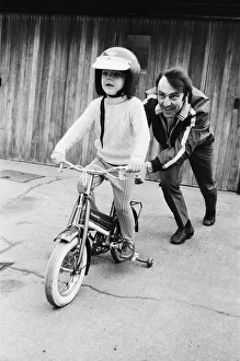 Images Dated 16th April 1970: Jimmy Greaves pushing his 4-year old son Andrew, wearing his fathers crash helmet