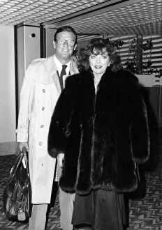 Joan Collins and Roger Moore at Heathrow airport, July 1988