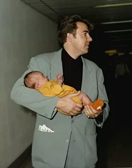 Images Dated 18th August 1991: Jonathan Ross TV presenter holds baby in arms