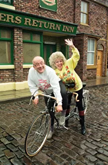 Images Dated 13th February 1990: Julie Goodyear and Roy Barraclough pictured on a tandem bike on the set of Coronation
