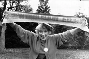 Images Dated 30th April 1988: June Whitfield, actress and Wimbledon Football Club supporter holds the teams scarf aloft