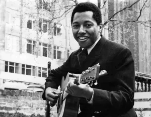 Labi Siffre with his guitar in a City Garden. May 1970 P005510 Labi Siffre with his guitar in a City Garden. May 1970 P005510