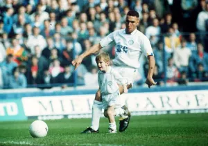 Images Dated 23rd October 1989: Leeds United footballer Vinnie Jones tackling the match mascot. 23rd October 1989