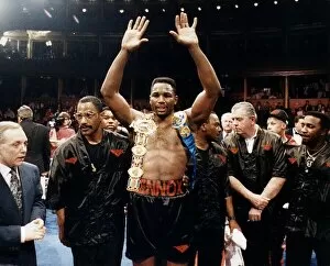 Lennox Lewis Boxer raises his hands with his belts on her shoulders after beating Derek