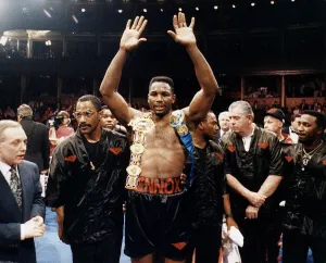 Lennox Lewis Boxer raises his hands with his belts on her shoulders after beating Derek Lennox Lewis Boxer raises his hands with his belts on her shoulders after beating Derek