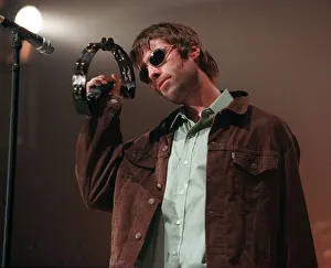 Liam Gallagher performing on stage playing a tambourine at an Oasis concert at the SECC Liam Gallagher performing on stage playing a tambourine at an Oasis concert at the SECC