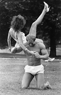 Linda Lusardi being lifted by a muscley nearly naked Julien Mess in the park