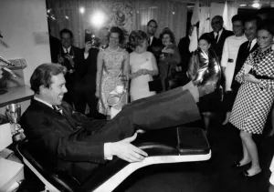 Lord Snowdon trying out the motorised reclining dentist chair at the exibition Lord Snowdon trying out the motorised reclining dentist chair at the exibition