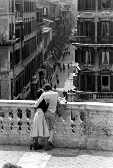 Loving couple look down over a street in the city of Rome, Italy April 1975