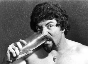 Male Stripper Mel biting a pint glass. June 1977 P018598 Male Stripper Mel biting a pint glass. June 1977 P018598