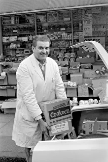 A man loading goods into the boot of his car in his shop at Deptford A man loading goods into the boot of his car in his shop at Deptford