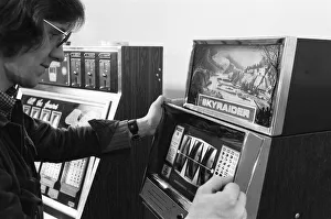 Man playing a one arm bandit slot machine in a London amusement arcade. 8th January 1975 Man playing a one arm bandit slot machine in a London amusement arcade. 8th January 1975