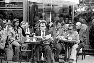 Images Dated 21st April 1975: Man reading a newspaper and smoking a cigar as he sits outside in a cafe on the streets