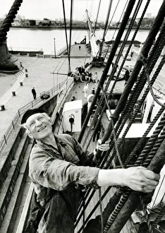 A man of the sea perched high above the deck of the Cutty Sark returns the wave to two A man of the sea perched high above the deck of the Cutty Sark returns the wave to two