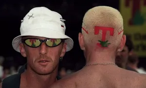 Man with T in the Park logo sunglasses with the back of a mans head with the T in Man with T in the Park logo sunglasses with the back of a mans head with the T in