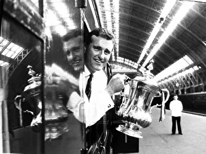 Core93 Gallery: Manchester United captain Noel Cantwell leaning from the train with the FA cup trophy at