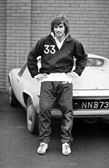 Core61 Gallery: Manchester United star George Best poses next to his Lotus Europa car after a training