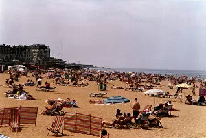 Margate Beach with tourists and daytrippers sunbathing. People sitting on deck chairs