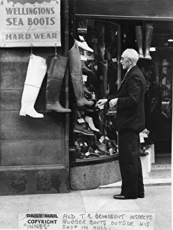 May 1950. Alderman TR Broadbent looking at a shop display of boots outside a shop by May 1950. Alderman TR Broadbent looking at a shop display of boots outside a shop by