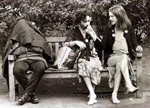 Men dressed as women sitting on a park bench as they take a break from the gay pride
