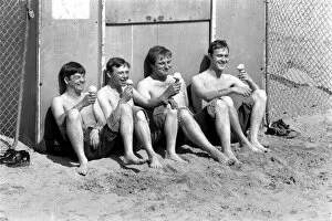Four men sitting enjoying an ice cream in the hot weather at Margate Beach