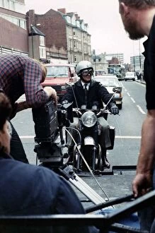 Images Dated 7th September 1989: Michael Elphick actor sitting on motor bike attached rig on the back of lorry filming for