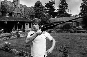 Mike Oldfield muscian at home holding a gun