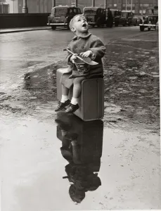 00001 Prints: Black and white Print of a young boy standing alone in the rain