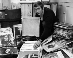 00030 Prints: A man stands in his home, cleaning a stack of 486 vinyl records