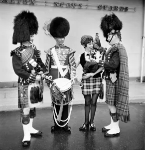 Black and white photograph print of a woman attempting to play the bagpipes