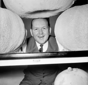 00033 Prints: Black and white photograph print of a man holding a large pumpkin