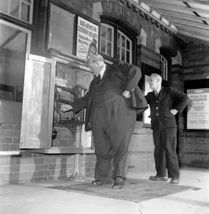 00038 Prints: Print of Fat Man John Feathestone buying a railway ticket