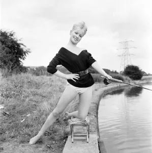 Beachwear Model Prints: Clothing: Fashion: Beachwear: Model by the river bank fishing. August 1963 E490-004