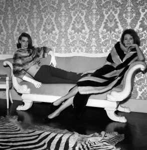 60s Fashion Trends Prints: 1960s Fashion Clothing December 1962 Models wearing Fur Coats reclining on a sofa