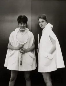 Fashion In The 60s Prints: Models Sandra Russell (left) and Judy Wilson showing a zip-up hooded cape in fur fabric