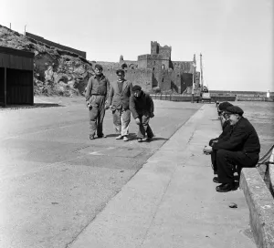 Prints of Peel Castle on St Patricks Isle, Isle of Man serves as a background to a Jeu de Boule game played by three stormbound Breton Fishermen. They play the game with some stones they found Isle Of Man Prints: Peel Castle Print, Isle of Man, May 1954