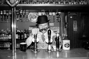 Prints of Bobby Moore preparing for the opening of his own public house called Moores at Stratford Broadway, East London. He is wearing a bowler hat and false moustache Stratford Prints: Bobby Moore at Moores Public House Print, 17th November 1976
