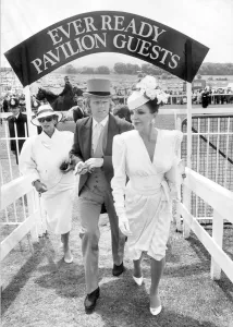 01415 Prints: Joan Collins and Peter Holm Print, Epsom Racecourse Arrival 1986