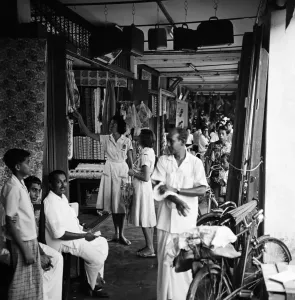 Black and white print of two women shopping in a market