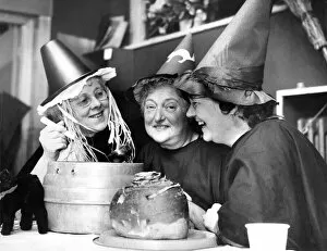 Mixing up a strong brew in their cauldron, three witches at the Halloween party held by