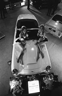 Sports Car Collection: Models pose on the bonnet of a Aston Martin Volante at Motor Show 15th October 1968