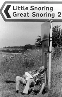 Morris Codling snoozes with his grandson under a signpost in Norfolk Morris Codling snoozes with his grandson under a signpost in Norfolk