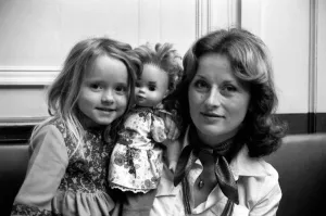 Mother and daughter with girls doll in a cafe on the Champs Elysees in Paris, France Mother and daughter with girls doll in a cafe on the Champs Elysees in Paris, France