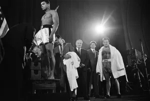Muhammad Ali stands on the scales as Brian London looks on at the weigh-in ahead of their Muhammad Ali stands on the scales as Brian London looks on at the weigh-in ahead of their