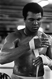 Portrait Posed Gallery: Muhammad Ali wrappings his hands in the gym at his training camp in Deer Lake