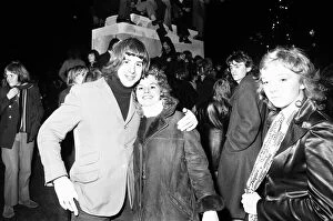 Images Dated 31st December 1971: New Year revellers pose for the camera while in the background revellers climb the statue