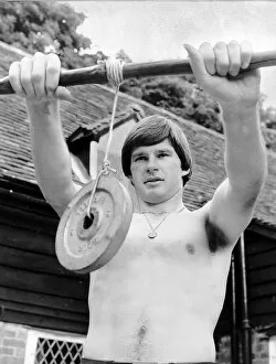 Nick Faldo Golf stands bare chested as he exercises his wrists by holding a weight